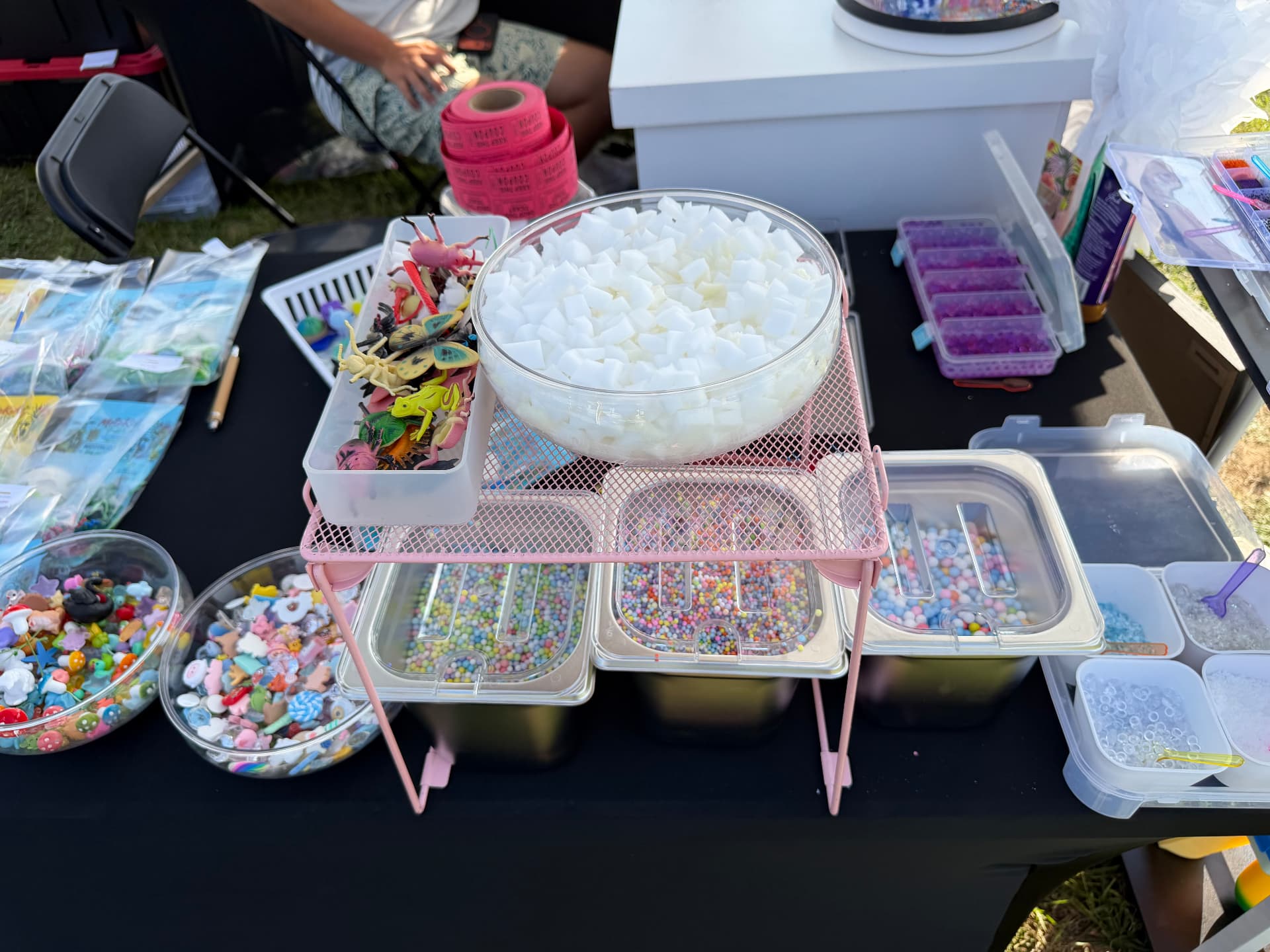 Foam beads, mini figures and colorful add-ins arranged in trays for slime making